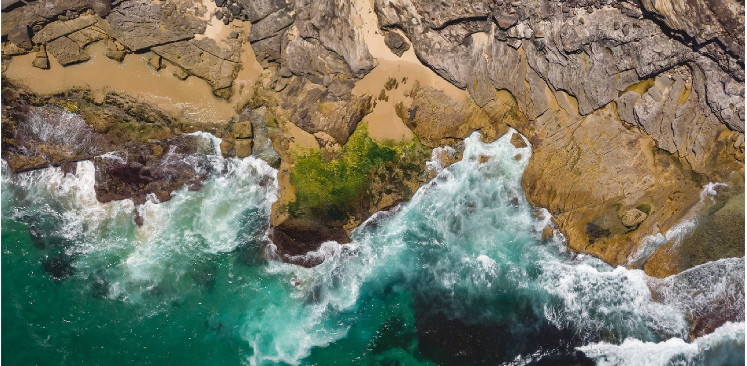 Marine shales along the coast of Australia - A photo of the coastline of Australia with cliffs and rock formations. The photo shows layers of sedimentary rocks that include marine shales, which are a source of various minerals including clay. The rocks are characterized by their distinct layers and colors, ranging from dark grey to light beige, and are shaped by the forces of wind, water, and time.